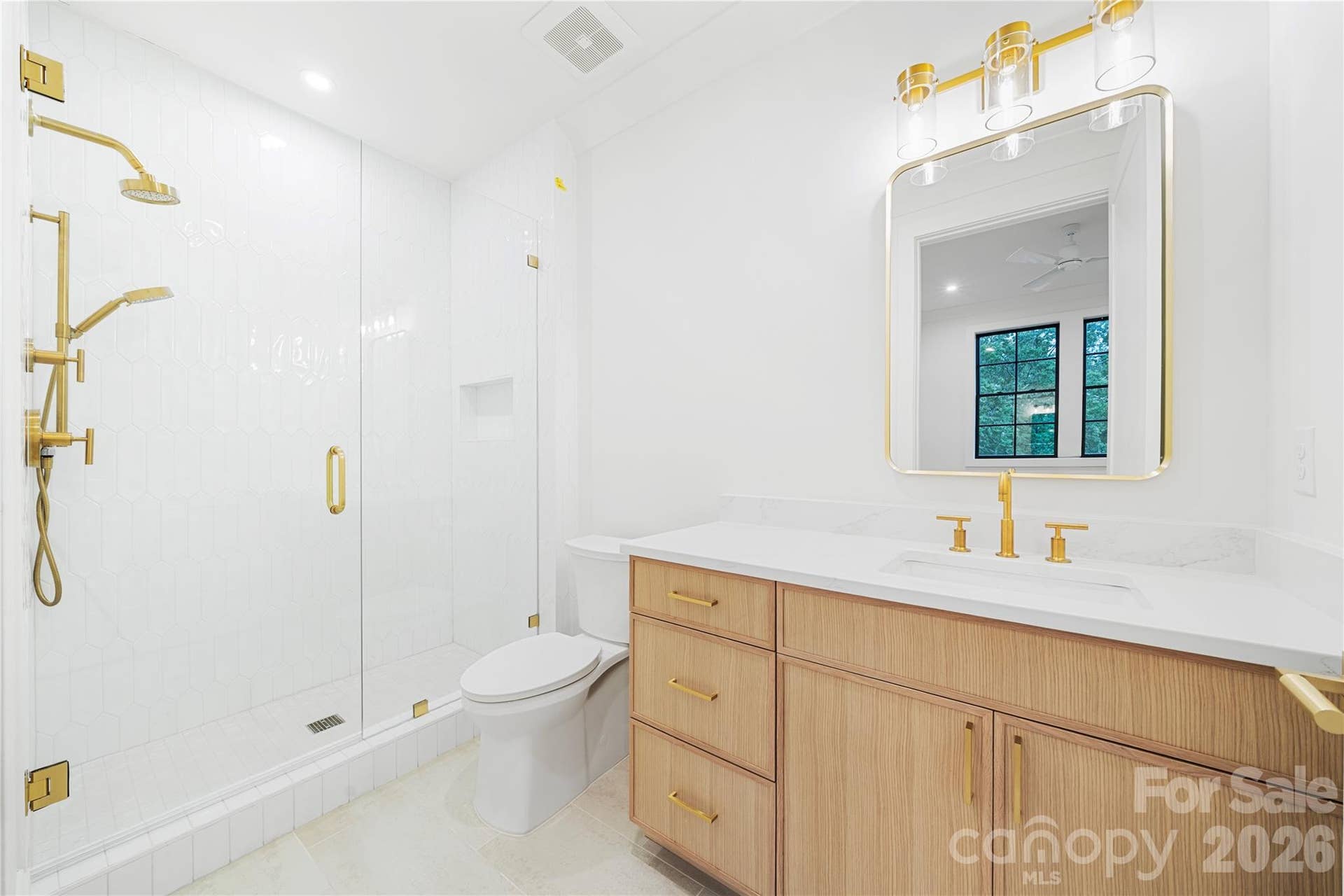 409 Queens Road, #503, Charlotte, NC 28207 The bright full bath with a glass-enclosed shower and custom cabinetry of bedroom 3.