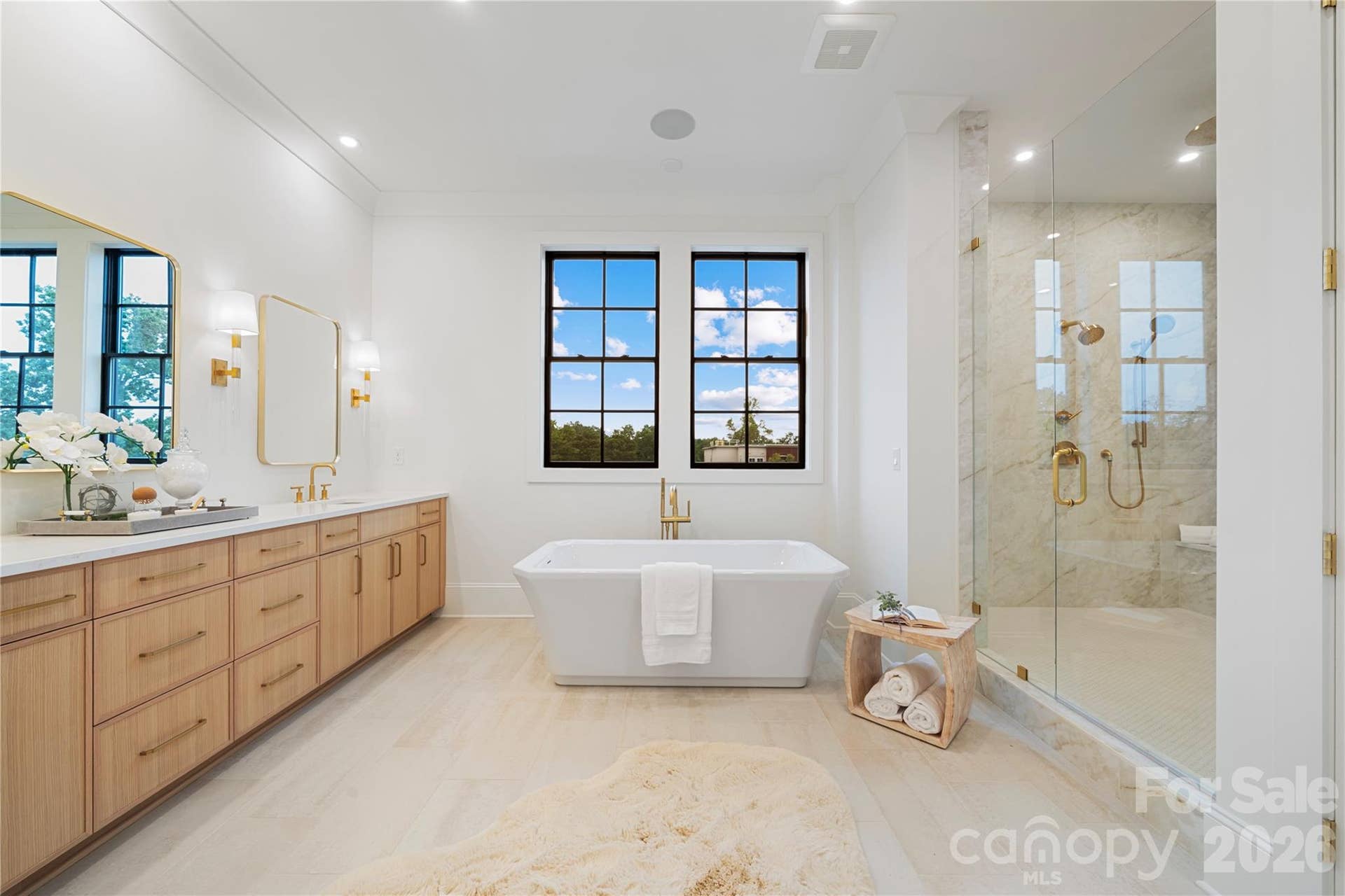 409 Queens Road, #503, Charlotte, NC 28207 the spa-inspired primary bath provides a freestanding soaking tub, custom dual vanity, natural stone finishes, a goergeous double-wide viewing window and an extraordinary glass-enclosed shower.