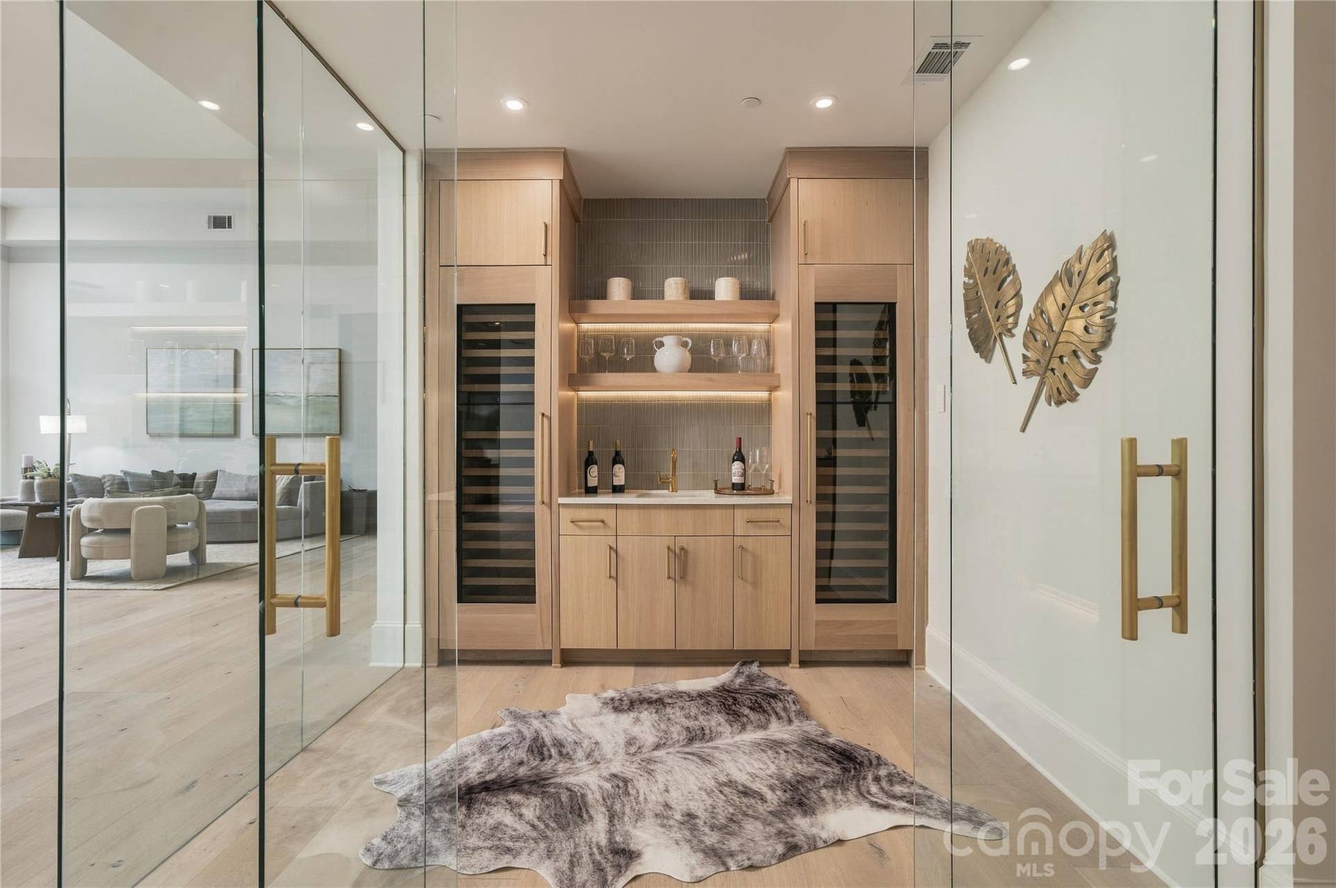 409 Queens Road, #503, Charlotte, NC 28207 Striking wine room with dual temperature-controlled wine refrigerators, custom cabinetry, illuminated shelving and warm brass accents. A beautifully finished glass-enclosed wine room with dual wine refrigerators, custom cabinetry, illuminated shelving and a wet bar for effortless entertaining.