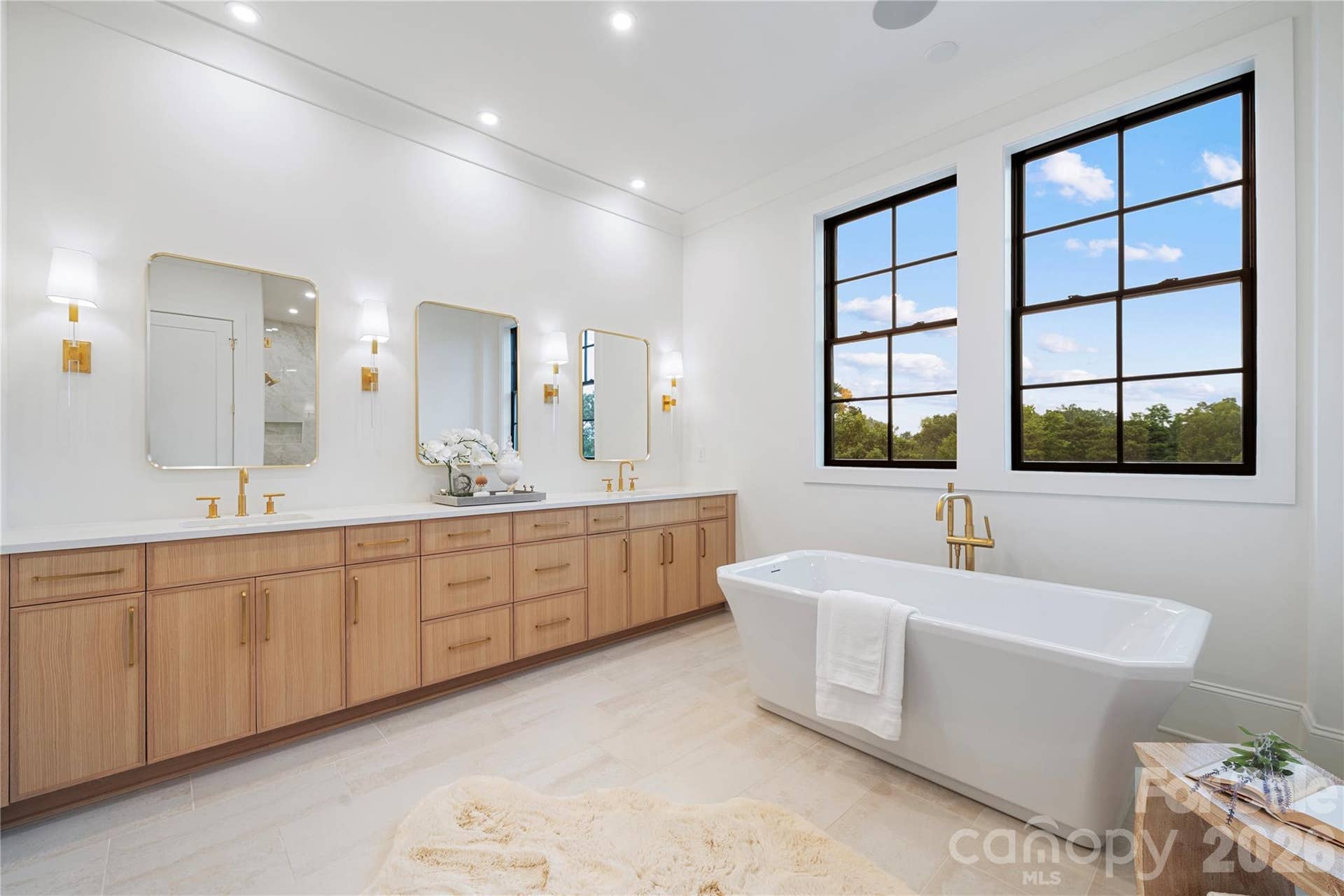 409 Queens Road, #503, Charlotte, NC 28207 The expansive custom vanity with dual sinks, triplet mirrors and abundant cabinetry ties the room together and fulfills every need for this extraordinary primary spa.