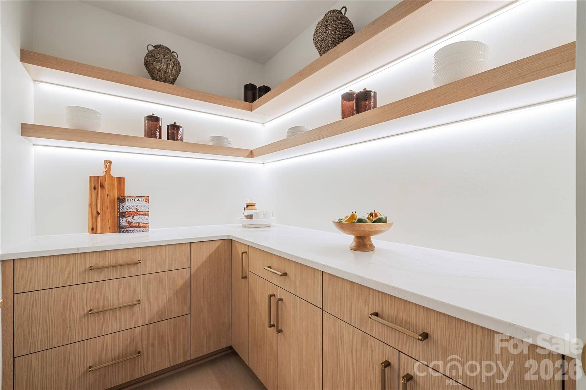 409 Queens Road, #503, Charlotte, NC 28207 Spacious walk-in pantry with generous counter space, extensive cabinetry and illuminated open shelving for beautifully organized storage.