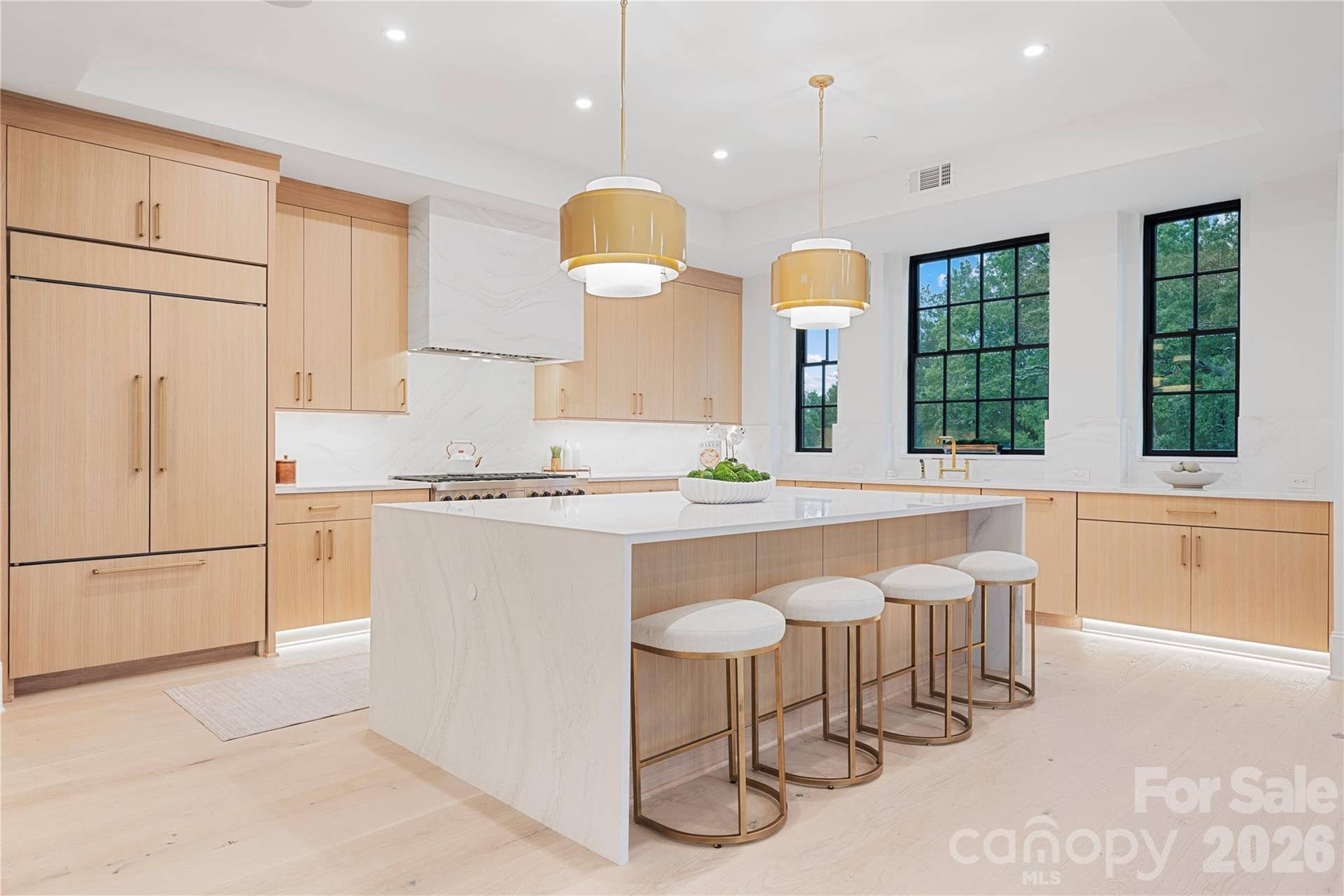 409 Queens Road, #503, Charlotte, NC 28207 The beautifully designed gourmet kitchen with a large waterfall-edge syled island, custom light-wood cabinetry, dramatic stone surfaces and abundant natural light.
