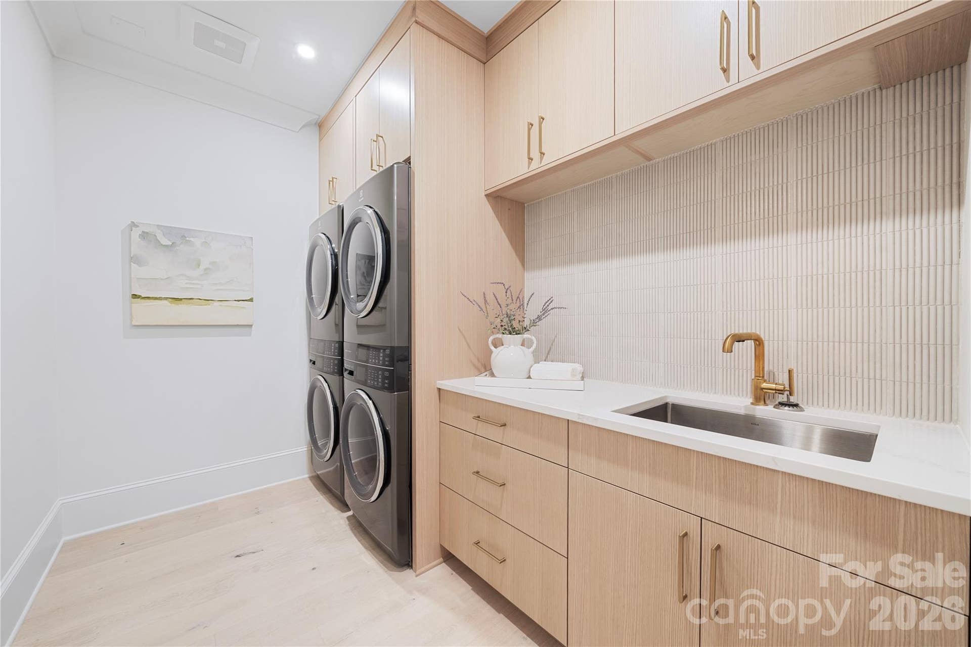 409 Queens Road, #503, Charlotte, NC 28207 The well-appointed laundry room provides a double washer, and a double dryer setup! This unique private laundry provides extensive custom cabinetry for storage, a double wide stainless steel utility sink and generous counter space for everyday convenience.