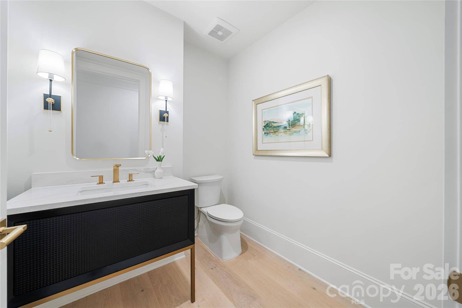 409 Queens Road, #503, Charlotte, NC 28207 The contemporary powder room with distinctive dark vanity and marble countertop presents an elegant and contemporary aspect.