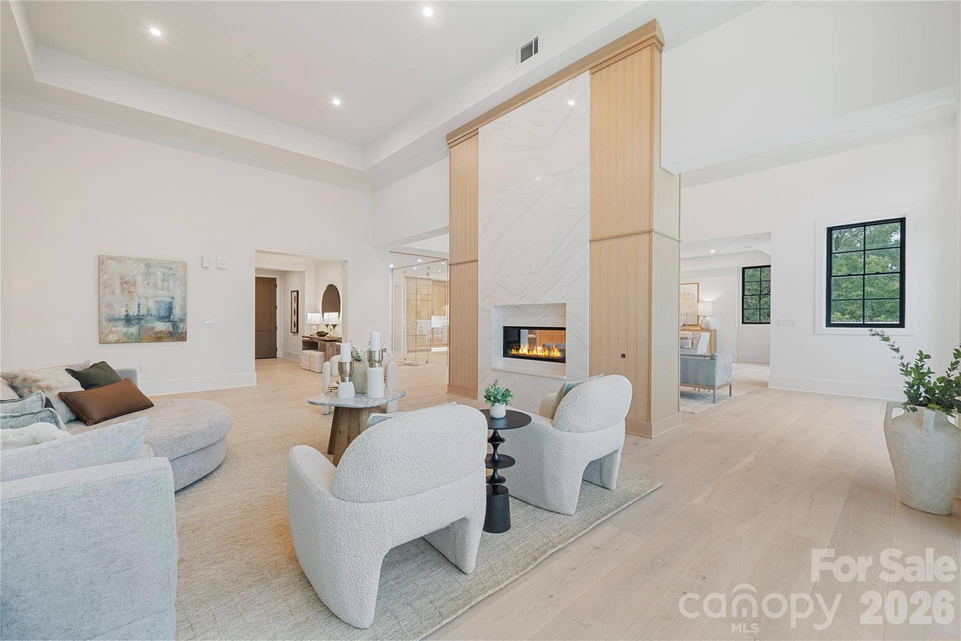 409 Queens Road, #503, Charlotte, NC 28207 The striking two-sided fireplace with floor-to-ceiling stone and warm wood detailing anchors the main living spaces in this sophisticated and light-filled residence.