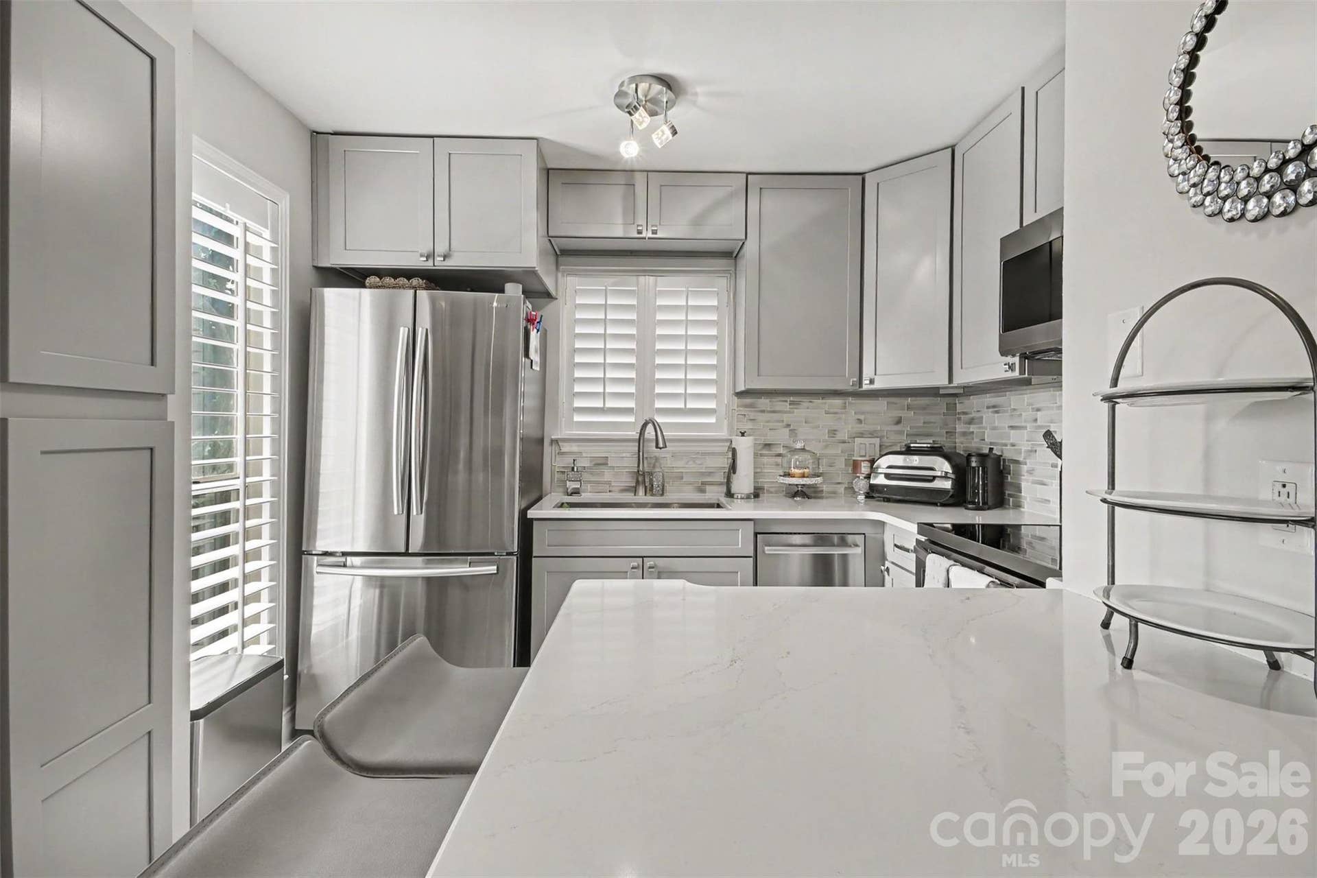 Quartz countertops, stainless steel appliances, laundry closet with custom cabinetry.