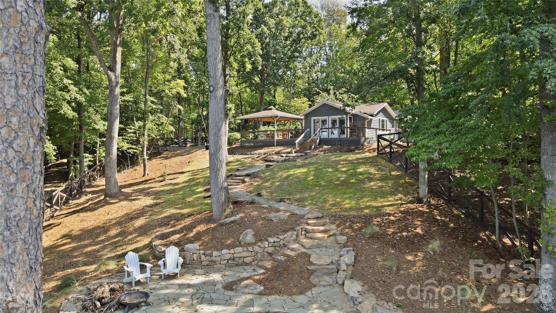 17424 Grasshopper Lane, Charlotte, NC 28278 Classic waterfront home offers glorious main channel views, beautiful landscaping, and mature hardwood trees
