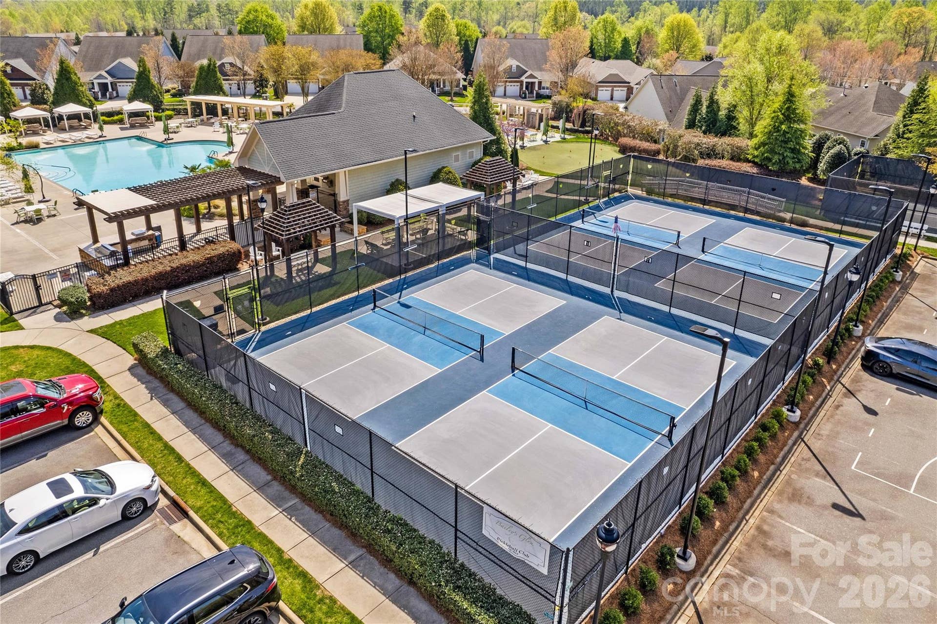 View of pickleball courts next to pool with putting green in the back