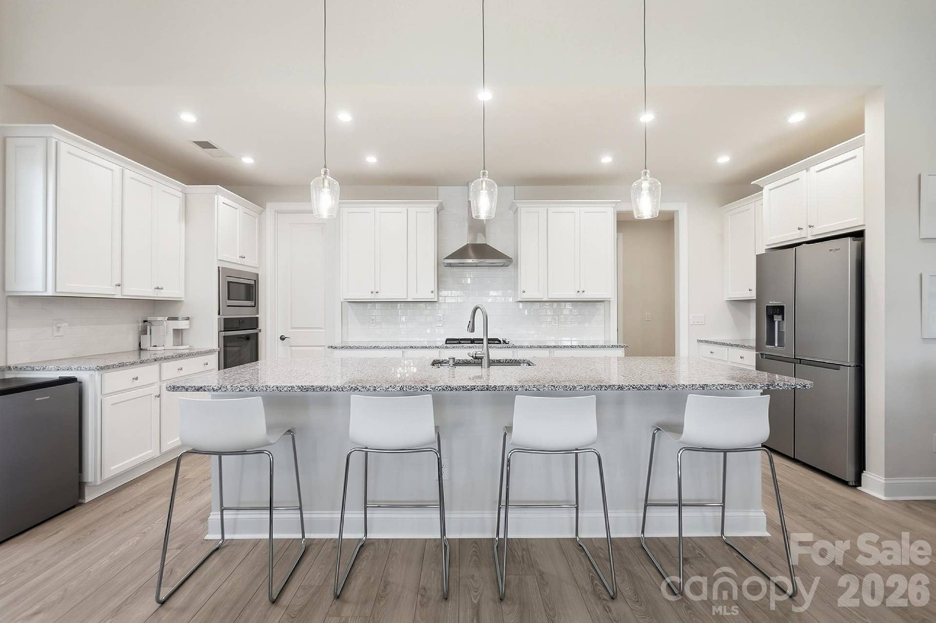 8032 Longwaters Court, York, SC 29745 The well-appointed kitchen features ss appliances, gas cooktop, wall oven, a large center island with abundant seating, and a spacious walk-in pantry, all opening to the dining area and great room