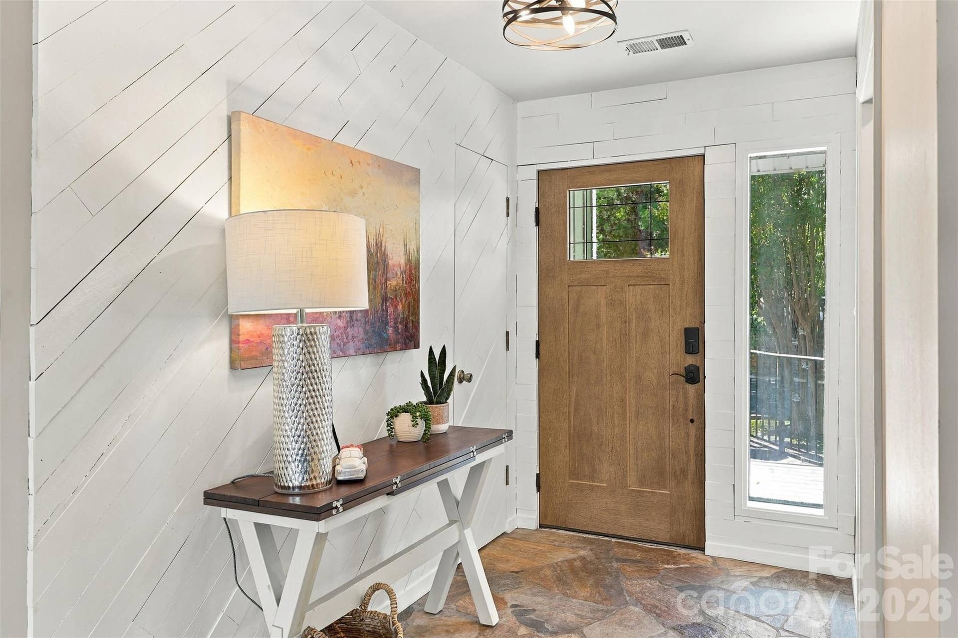 Foyer with stone flooring and painted wood accent wall