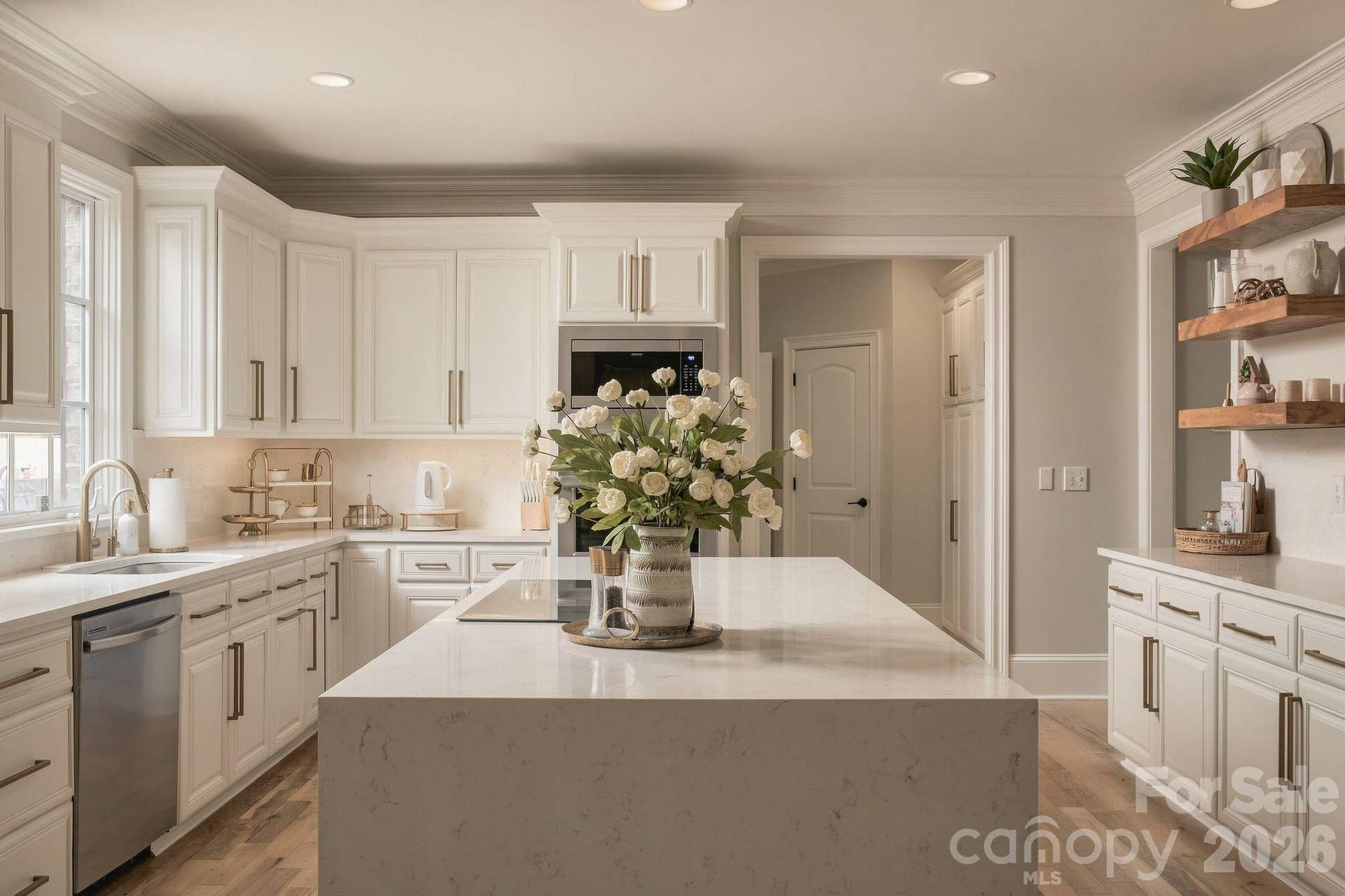 Large waterfall island with electric cooktop and stainless steel appliances