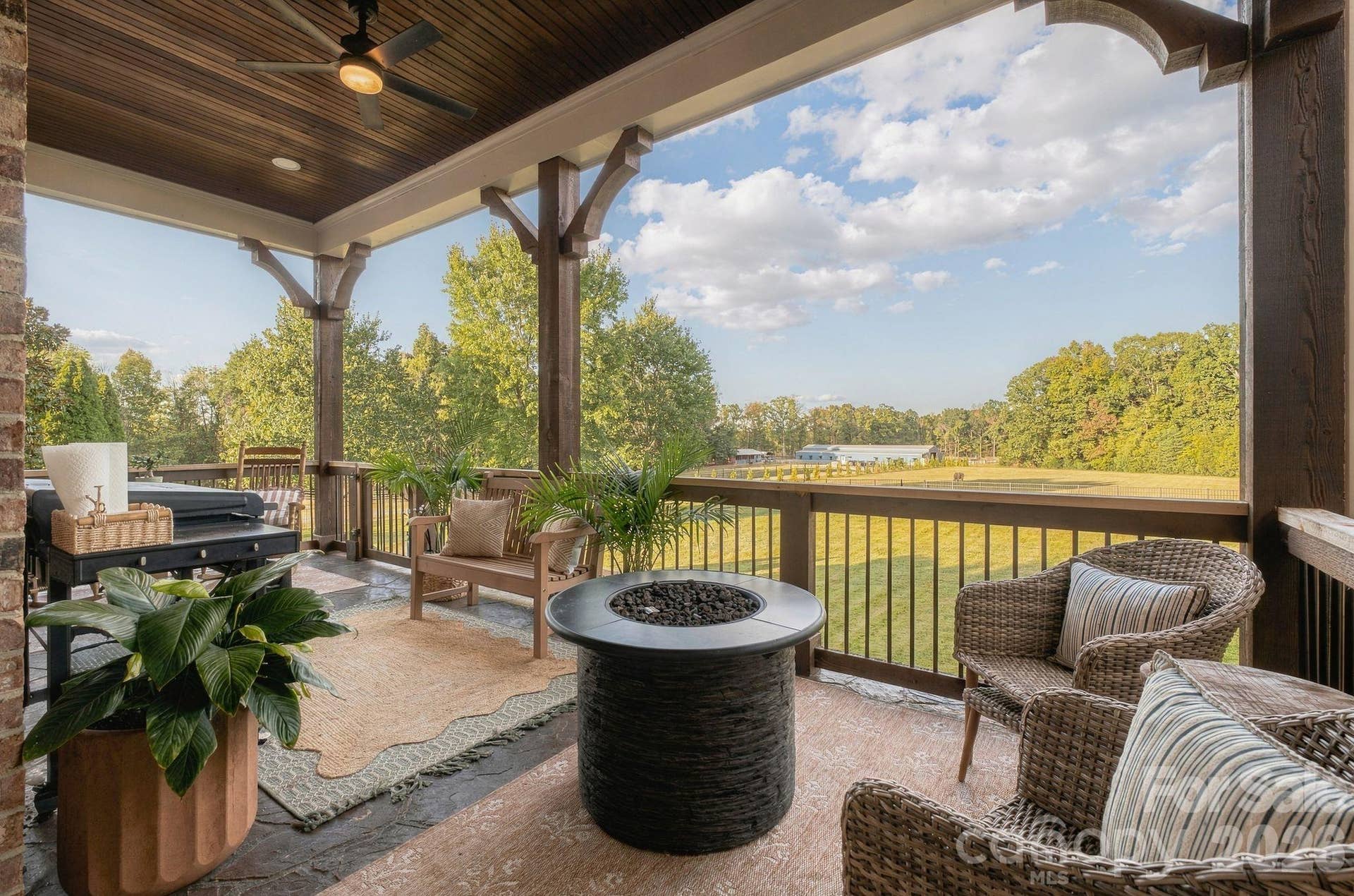Relax and unwind on the main level covered patio with gorgeous wooded views