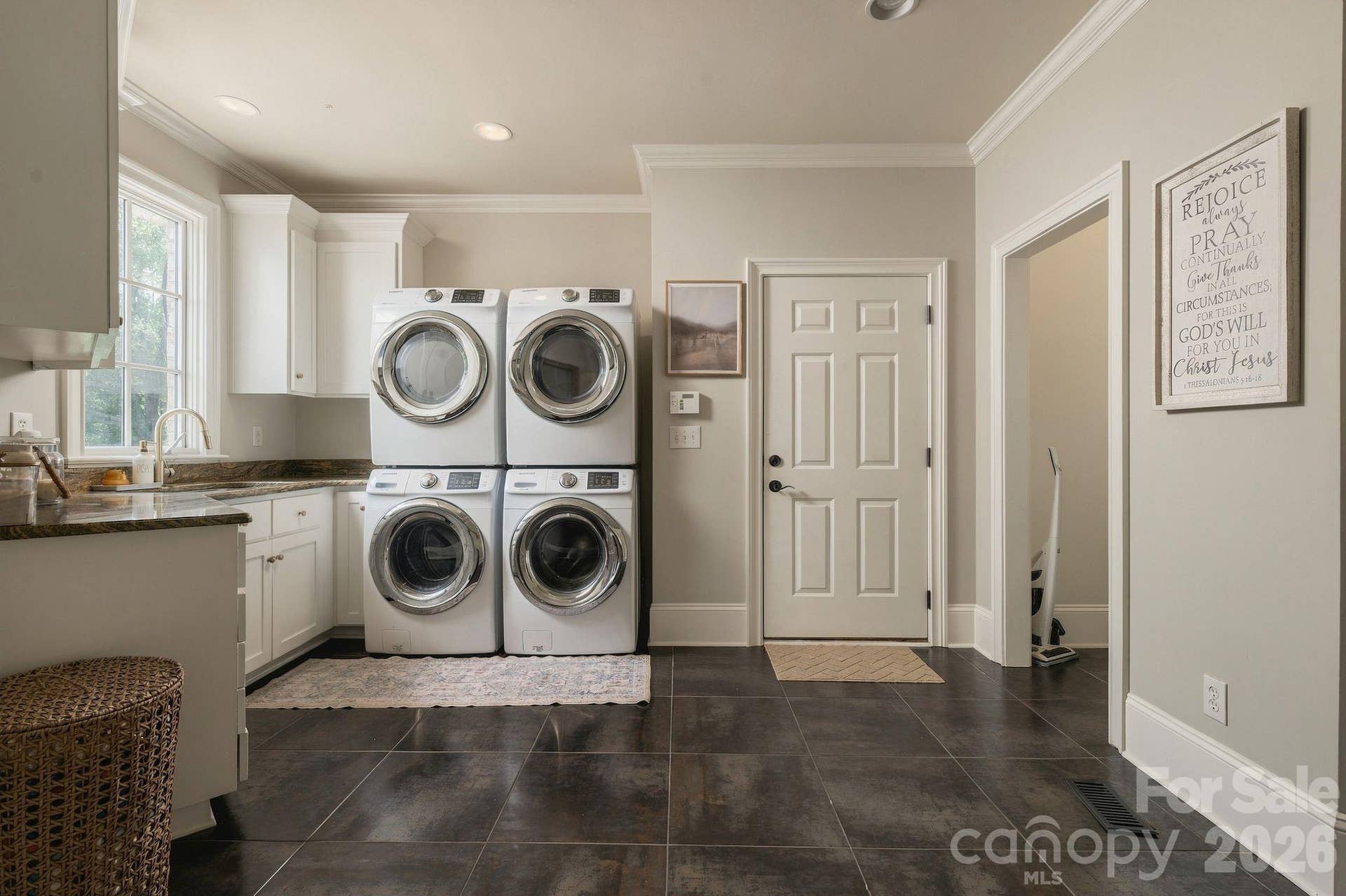 Large laundry room with full counter top, sink, and storage