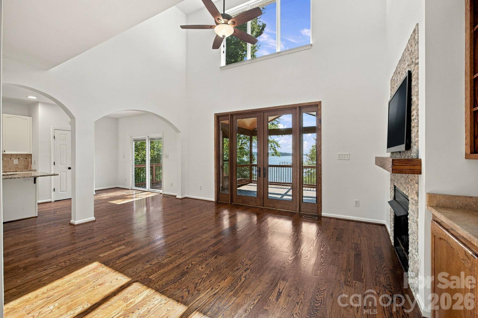 Large French doors open the room to the screened-in deck and beautiful lakeview staged