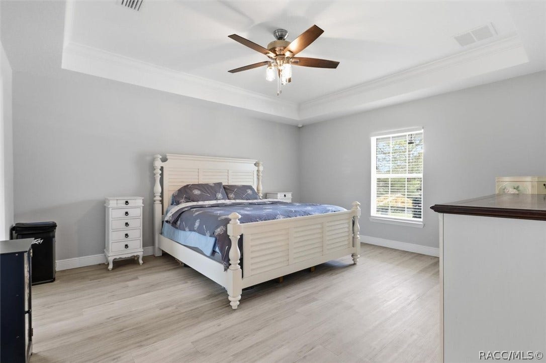 Spacious primary bedroom with tray ceiling