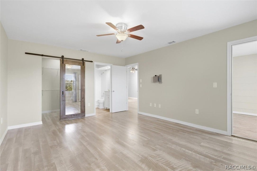 681 E Hartford Street, #6A, Hernando, FL 34442 Primary bedroom with ensuite and custom barn door to walk-in closet
