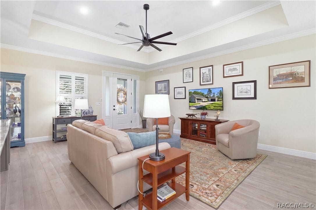 4124 W Pine Ridge Boulevard, Beverly Hills, FL 34465 OPEN GREAT ROOM Spacious living area highlighted by a tray ceiling, oversized modern ceiling fan, crown molding, recessed lighting & an easy open flow into the kitchen and dining spaces.