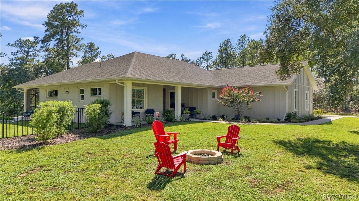 4124 W Pine Ridge Boulevard, Beverly Hills, FL 34465 FIRE-PIT SETTING
Peaceful outdoor gathering area surrounded by mature pines & natural wooded scenery. A circular stone fire pit surrounded by Adirondack-style seating creates an inviting spot for evening conversations, cool-weather fires & enjoying the privacy of the expansive yard. Adirondack chairs DO NOT CONVEY.