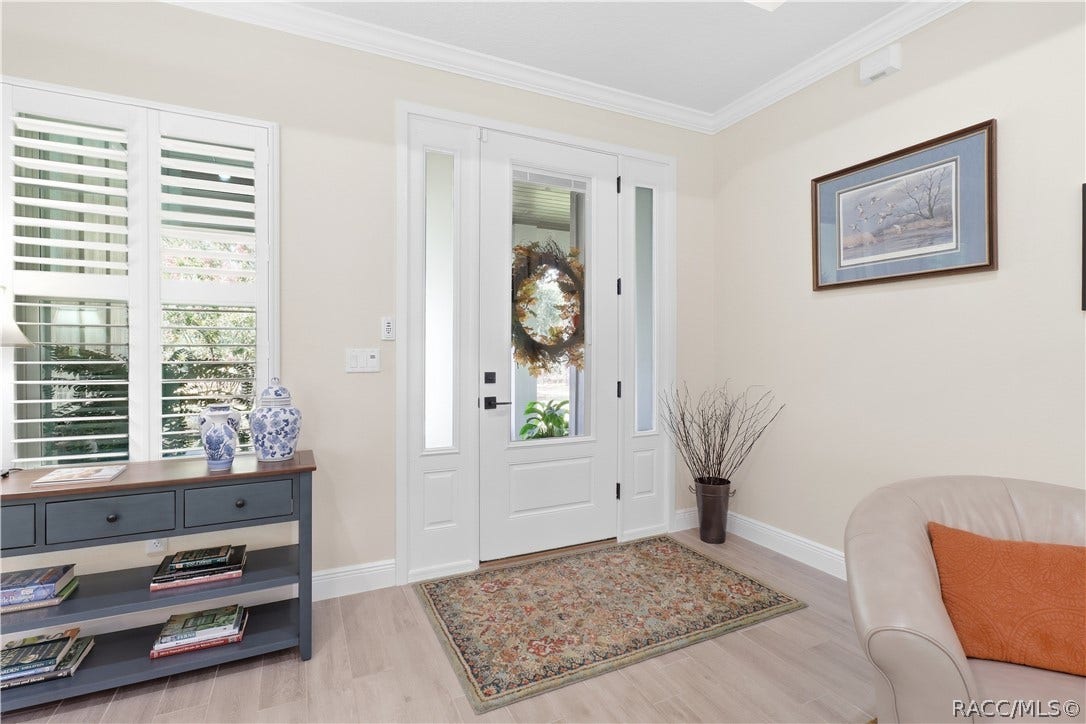 4124 W Pine Ridge Boulevard, Beverly Hills, FL 34465 BRIGHT FOYER Glass-paneled front door w/ sidelights fills the entry w/ natural light; plantation shutters, crown molding, wide baseboards & light-toned flooring add a polished finish.