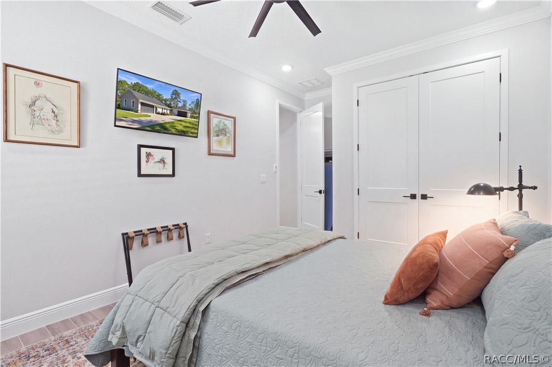 4124 W Pine Ridge Boulevard, Beverly Hills, FL 34465 GUEST BEDROOM 1 STORAGE Reverse view of the guest bedroom highlights the double-door closet, crown molding, recessed lighting, contemporary black hardware & plenty of space for substantial bedroom furniture.