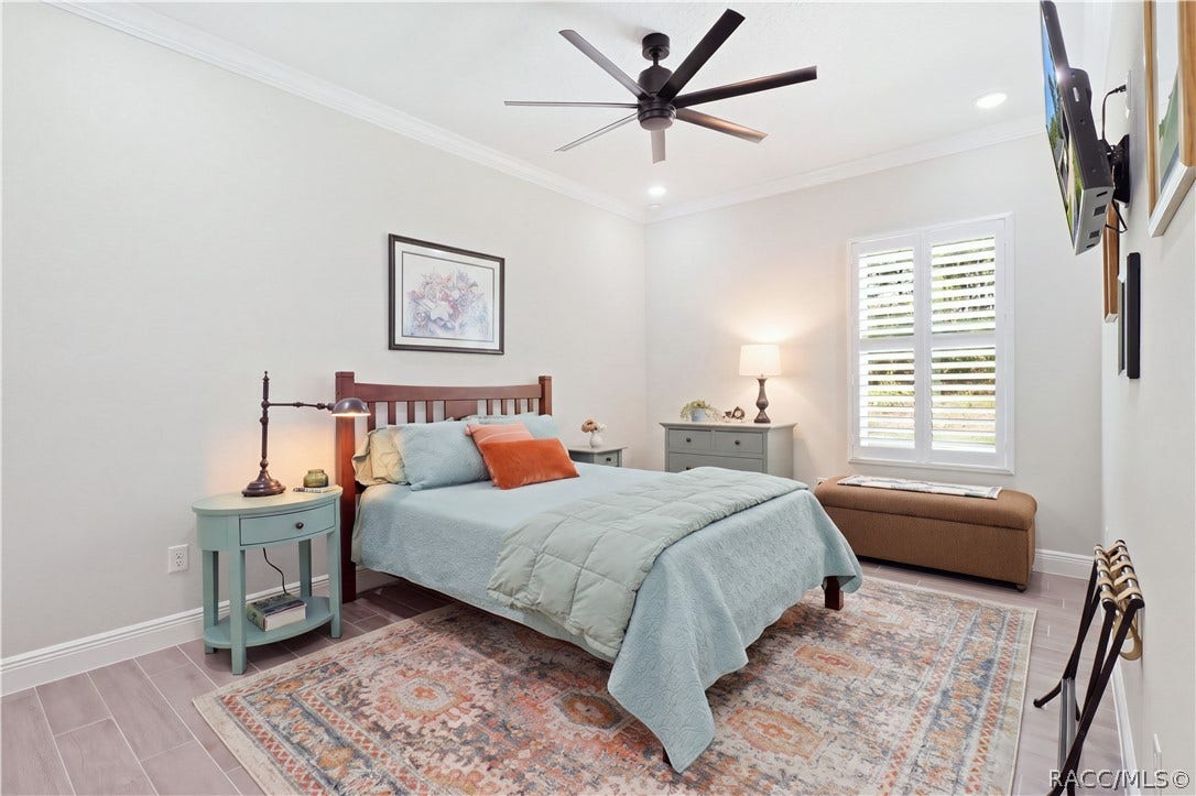 4124 W Pine Ridge Boulevard, Beverly Hills, FL 34465 GUEST BEDROOM 1 Bright, generously sized guest bedroom features crown molding, recessed lighting, oversized modern ceiling fan, porcelain tile flooring & plantation shutters for a polished, comfortable retreat.
