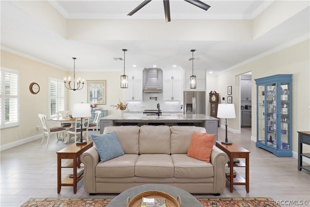 4124 W Pine Ridge Boulevard, Beverly Hills, FL 34465 OPEN GREAT ROOM Spacious living area highlighted by a tray ceiling, oversized modern ceiling fan, crown molding, recessed lighting & an easy open flow into the kitchen and dining spaces.