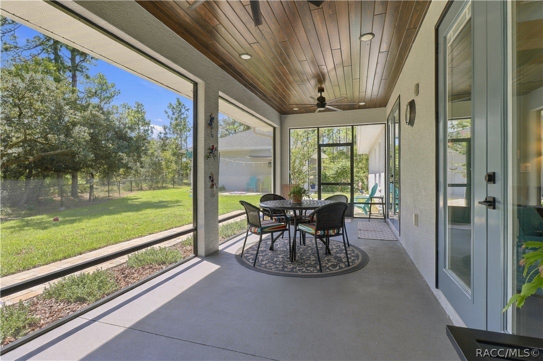 4124 W Pine Ridge Boulevard, Beverly Hills, FL 34465 SCREENED OUTDOOR LIVING Another view captures the impressive length of the screened lanai, wood-plank ceiling, recessed lighting & ceiling fan, all overlooking the fenced backyard. Multiple access doors make indoor/outdoor living effortless.