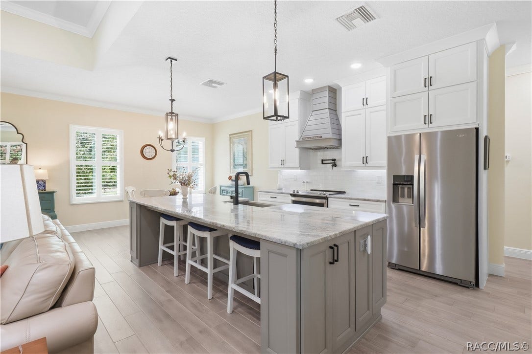 4124 W Pine Ridge Boulevard, Beverly Hills, FL 34465 OVERSIZED KITCHEN ISLAND Generous contrasting island provides substantial prep space & seating for three accented by granite counters, statement pendant lights, deep sink & modern black fixtures. Lots of Storage for all your needs!