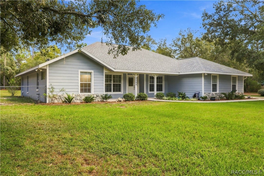 2593 S Columbine Avenue, Homosassa, FL 34448 Front Exterior BRAND NEW ROOF 2026 Attractive front view featuring a covered front porch, mature landscaping, stone accents sitting on a fully fenced 1.25 acres.