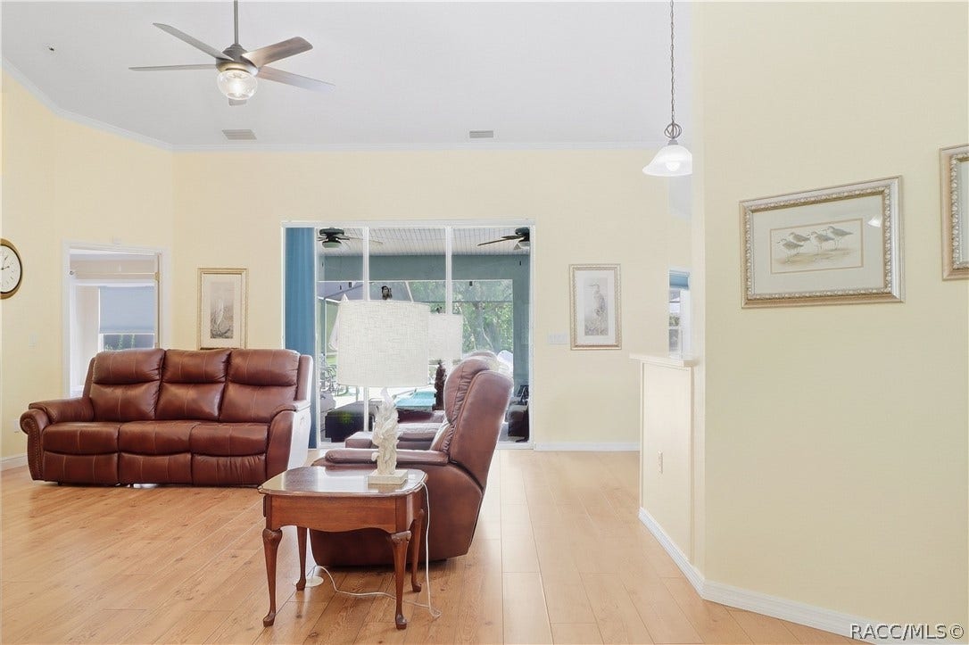 2593 S Columbine Avenue, Homosassa, FL 34448 Living Room Additional view showcasing the generous living space, vaulted ceiling, wood-look flooring & access toward the pool area.