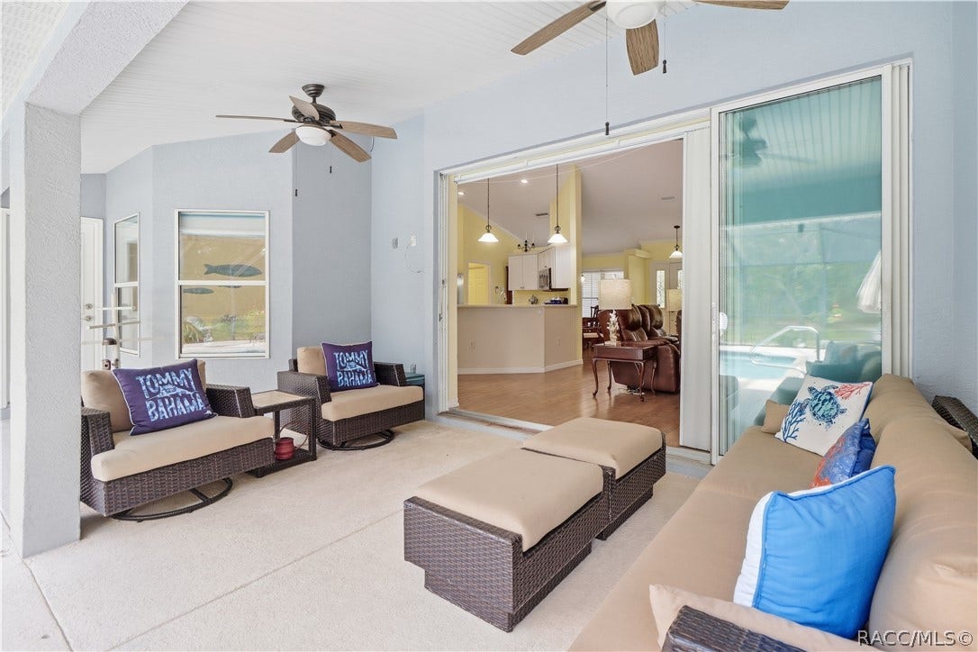 2593 S Columbine Avenue, Homosassa, FL 34448 Covered Lanai Alternate view showing the spacious seating area, dual ceiling fans and pocket sliding-door connection to the interior.