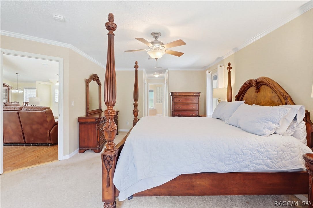 2593 S Columbine Avenue, Homosassa, FL 34448 Primary Bedroom Spacious primary suite with crown molding, ceiling fan, neutral finishes and private access toward the ensuite bath.
