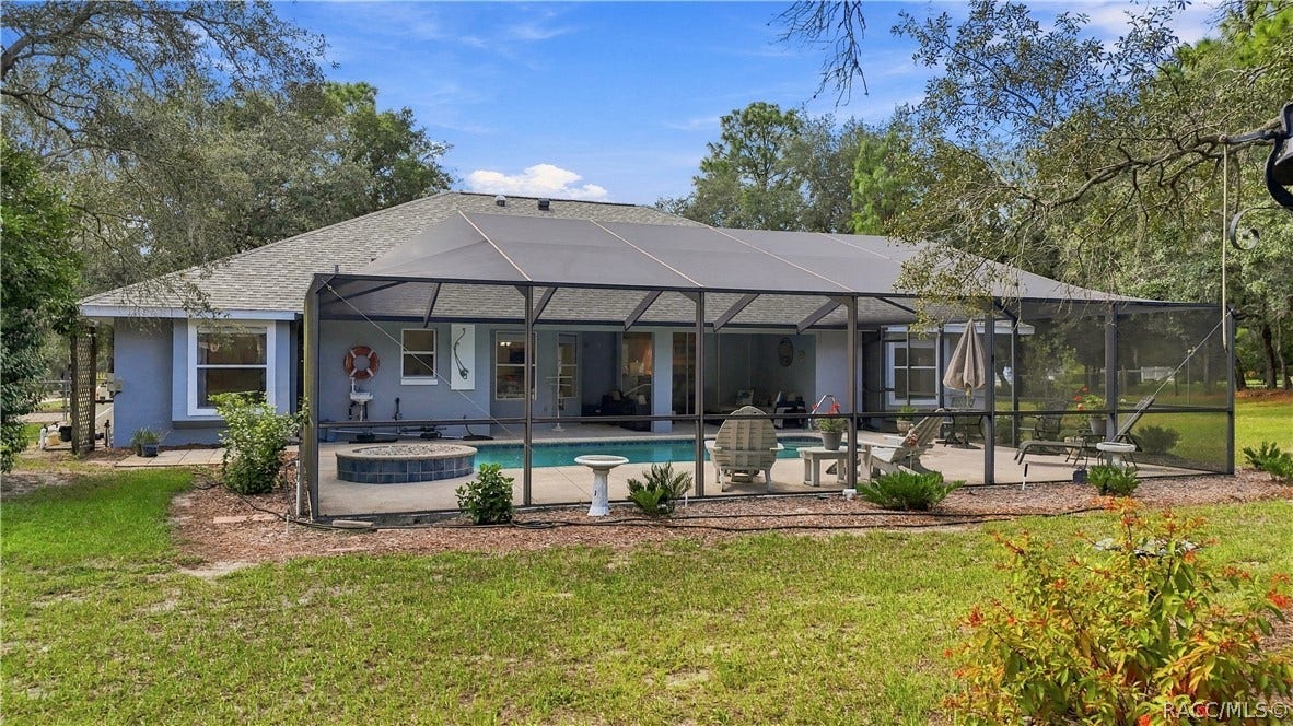 2593 S Columbine Avenue, Homosassa, FL 34448 A BACKYARD BUILT FOR FLORIDA LIVING Full view of the oversized screened pool enclosure extending across the rear of the home.