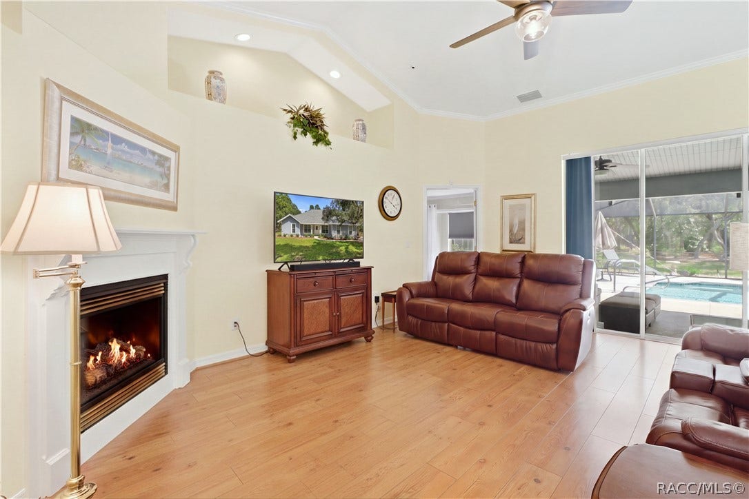 2593 S Columbine Avenue, Homosassa, FL 34448 Living Room / Pool View Open living space with gas fireplace and large sliding glass doors providing a direct view into the screened pool area.