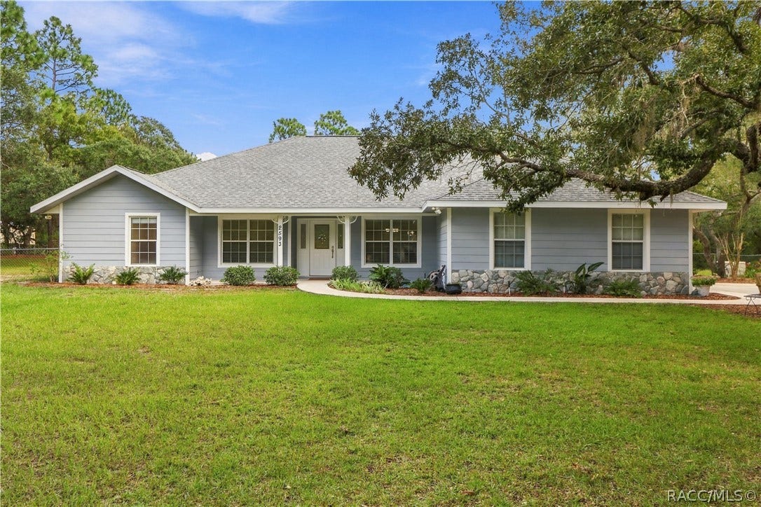 2593 S Columbine Avenue, Homosassa, FL 34448 Front Exterior BRAND NEW ROOF 2026 Full front elevation highlighting the expansive lawn, covered entry porch, mature shade trees. FRESHLY painted exterior trim.