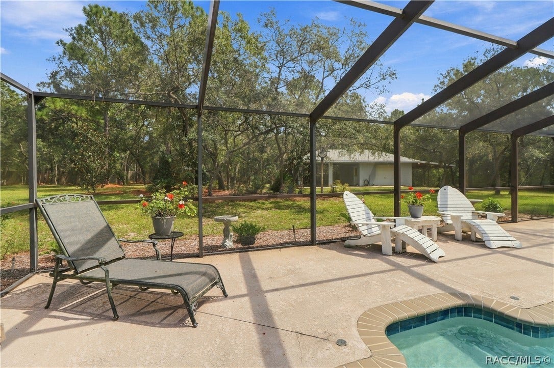 2593 S Columbine Avenue, Homosassa, FL 34448 Pool & Backyard View Screen-enclosed pool and spa overlooking the spacious backyard with mature trees and plenty of outdoor space.