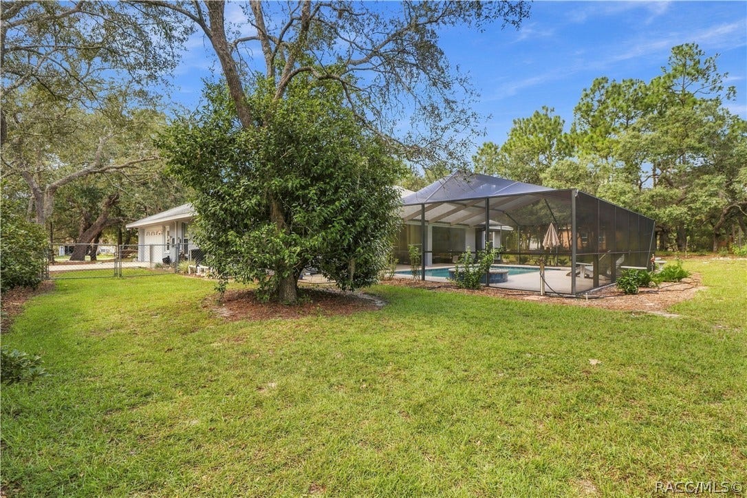 2593 S Columbine Avenue, Homosassa, FL 34448 ROOM TO SPREAD OUT Spacious backyard surrounded by mature trees with the screened pool area just steps from the home.