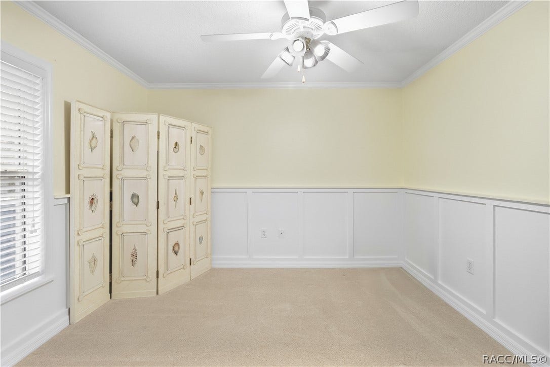 2593 S Columbine Avenue, Homosassa, FL 34448 Additional Guest Bedroom Alternate view highlighting the rooms size, natural light and decorative wall detail/wainscoating.