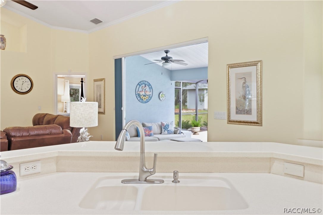 2593 S Columbine Avenue, Homosassa, FL 34448 Kitchen Breakfast Bar Generous counter space with raised breakfast bar, sink & open sightlines into the living room and screened pool lanai.