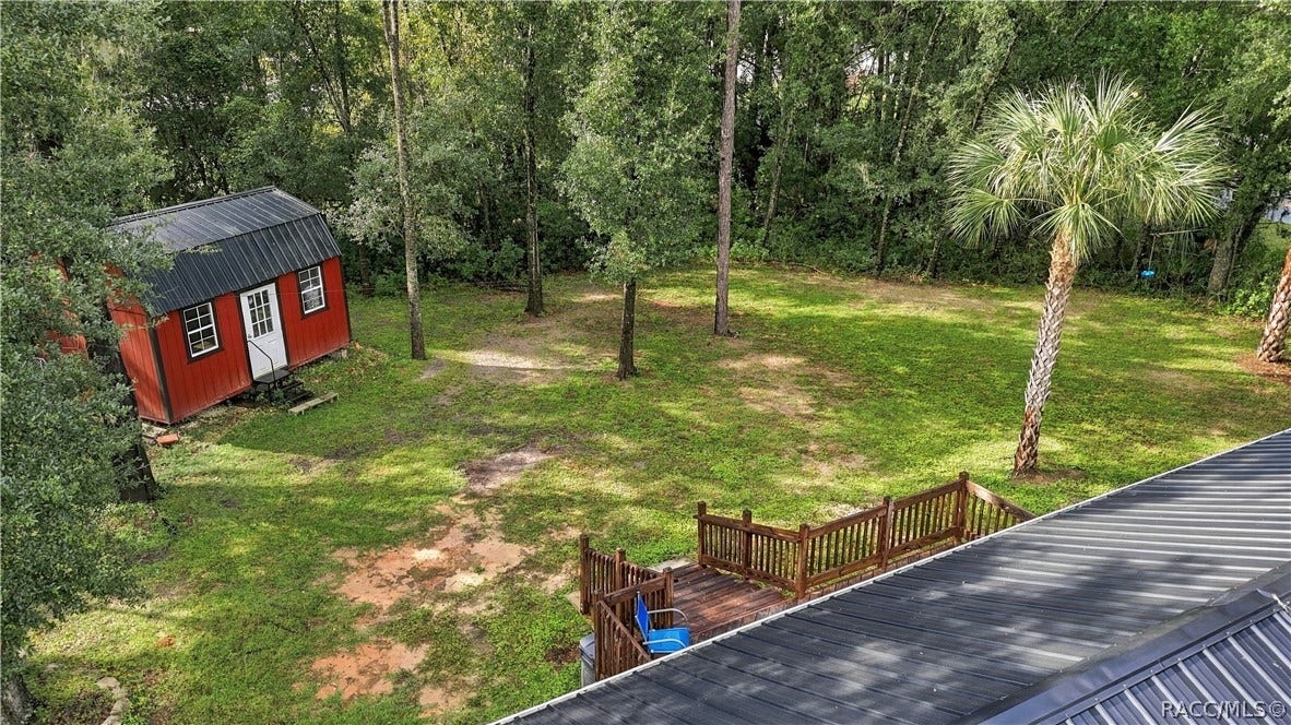6230 W Glen Robbin Court, Crystal River, FL 34429 Aerial Backyard View Enjoy the generous green space, mature shade trees, rear wooden deck & attractive red storage building that adds character to this inviting property.