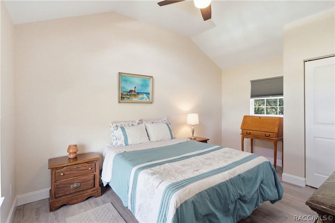 6230 W Glen Robbin Court, Crystal River, FL 34429 Primary Bedroom Cozy & inviting bedroom featuring VAULTED CEILINGS, luxury vinyl plank flooring, ceiling fan & coastal-inspired furnishings.