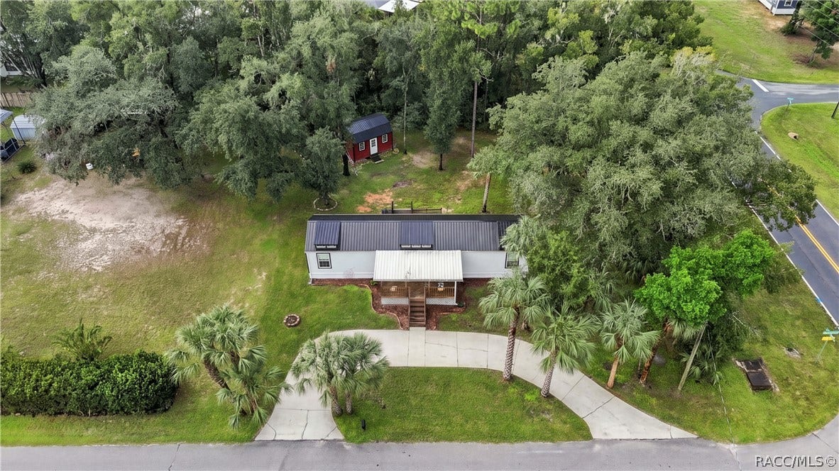 6230 W Glen Robbin Court, Crystal River, FL 34429 Aerial Property View A beautiful overhead perspective of the .29-ACRE CORNER HOMESITE, showcasing the METAL ROOF, COVERED FRONT PORCH, circular concrete driveway, mature trees & detached storage building.