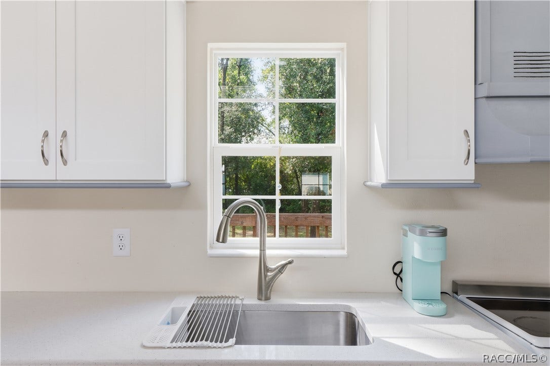 6230 W Glen Robbin Court, Crystal River, FL 34429 Kitchen Sink & Window Stainless-steel sink w/pull-down faucet, solid surface countertop & window overlooking the greenery outside.