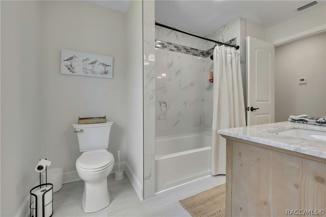 11806 W Riverhaven Drive, Homosassa, FL 34448 Bathroom with toilet and tub/shower with glass doors.
