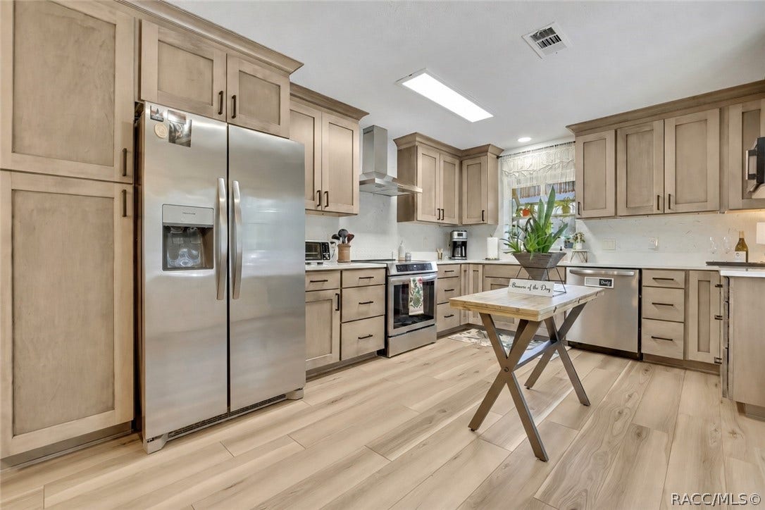 11806 W Riverhaven Drive, Homosassa, FL 34448 Kitchen with light wood cabinets and stainless refrigerator