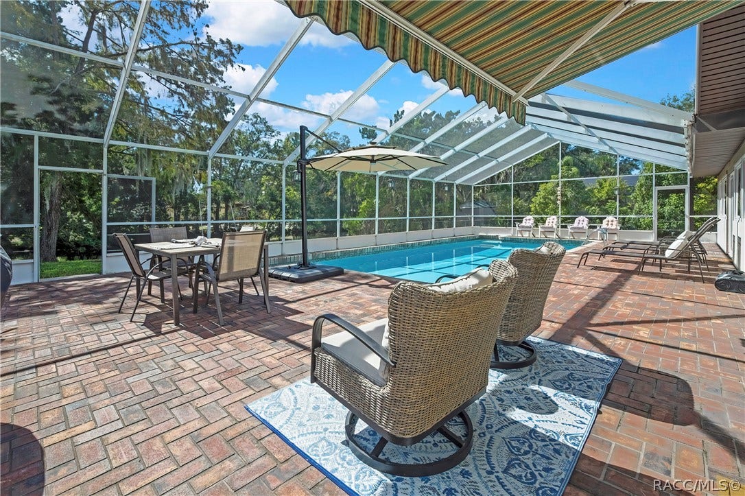 11806 W Riverhaven Drive, Homosassa, FL 34448 Screen-enclosed pool and brick paver deck with lounge seating