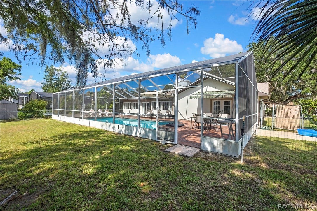 11806 W Riverhaven Drive, Homosassa, FL 34448 Back of the home and pool enclosure from the yard.