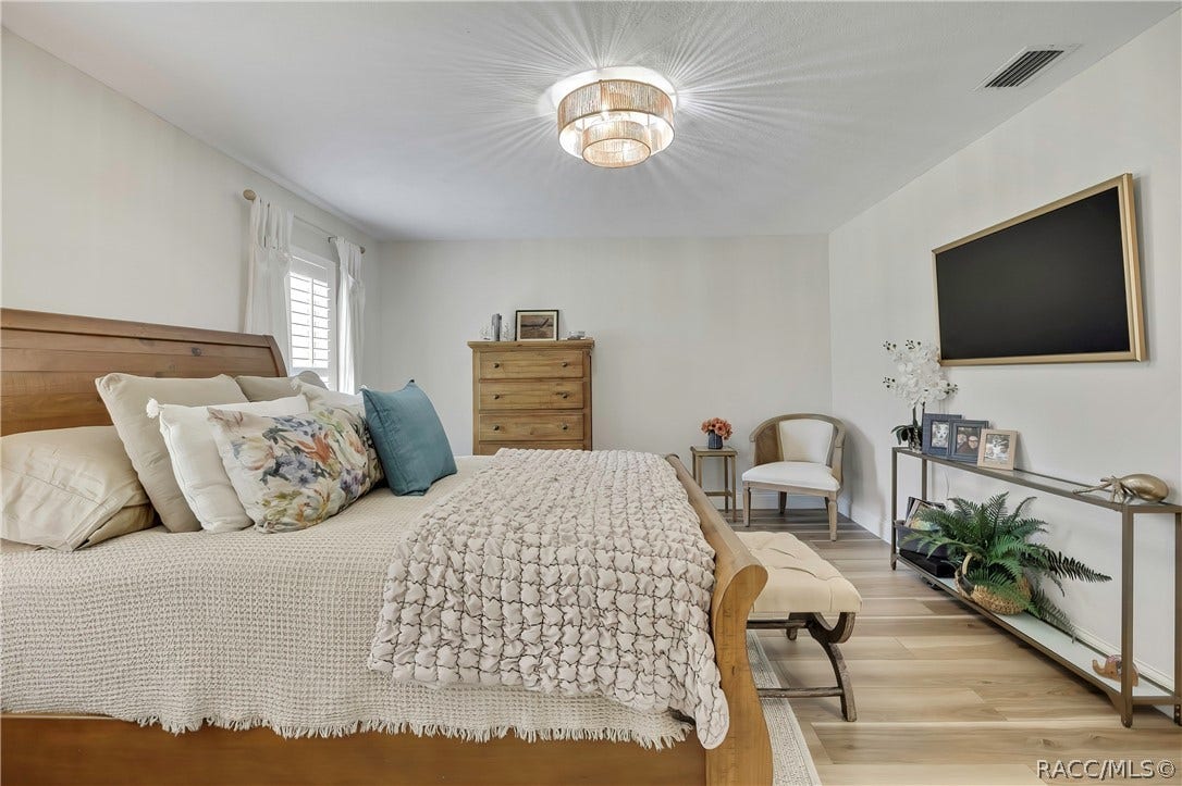 11806 W Riverhaven Drive, Homosassa, FL 34448 Primary bedroom with sitting chairs and dresser.