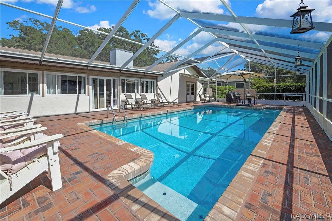 11806 W Riverhaven Drive, Homosassa, FL 34448 Pool with lounge chairs on the brick deck.