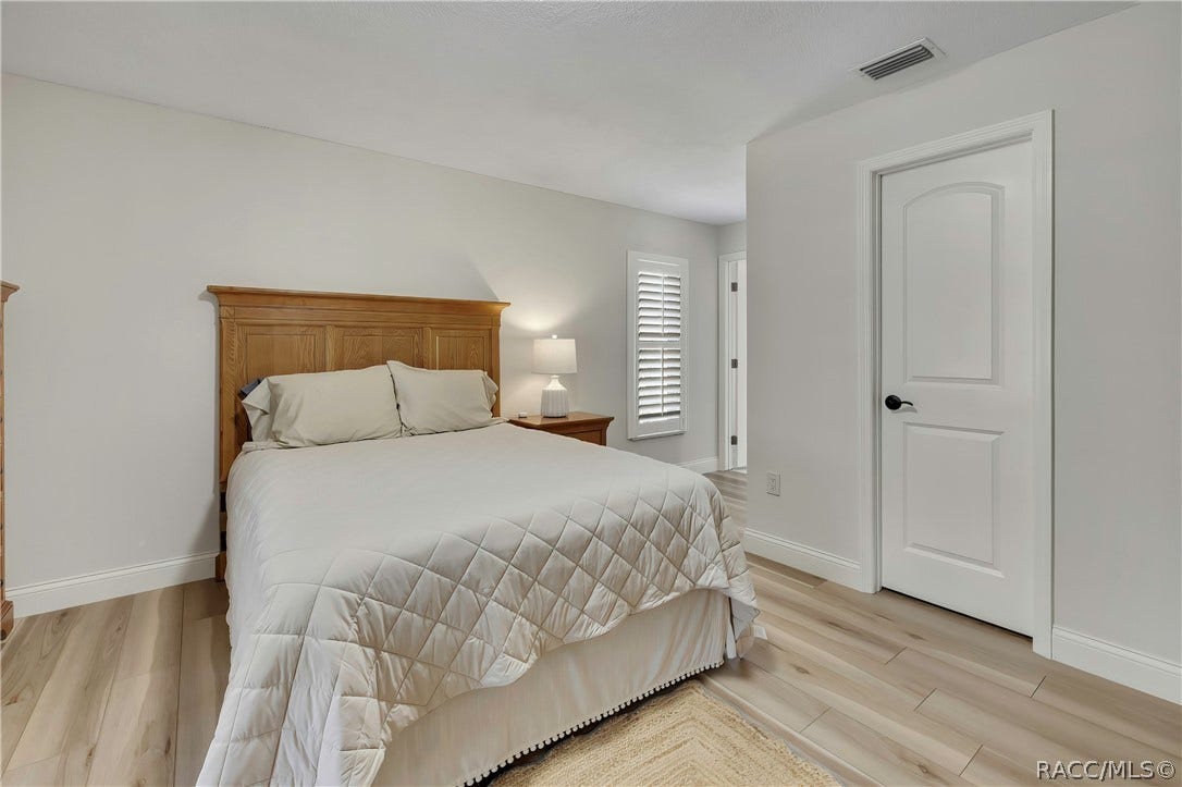 11806 W Riverhaven Drive, Homosassa, FL 34448 Bedroom with wood headboard and wood-look floors.